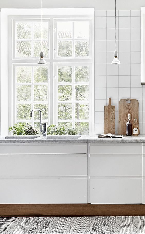 The kitchen counter (quartz? marble?) here is a gorgeous change of pace from the white surfaces, but not so much a contrast that it feels out of place. The windows inset at the sink gave space for a built-in herb garden too! #ThisOldHouse kitchen inspiration via www.L-2-Design.com