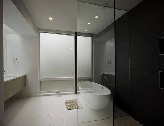 This bathroom layout, while having separated functions, still appears open due to the glass walls. The color contrast from wall to floor is nice, although a bit dark.