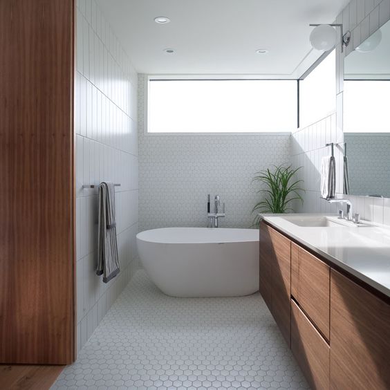 Architect Randy Bens created this serene bathroom space with a soaking tub for a modern home in Vancouver. I love how the floor tile comes up the wall in this linear space, acting as a backdrop for the pear-shaped tub. #ThisOldHouse inspiration via www.L-2-Design.com